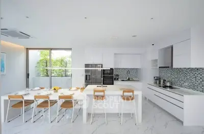 Sleek modern kitchen with open layout and stylish dining area, featuring high-end appliances and elegant design.