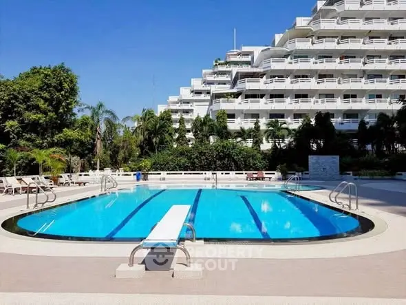 Luxurious residential building with stunning outdoor pool and lush greenery.