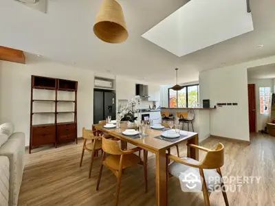 Modern open-plan dining area with wooden furniture and skylight