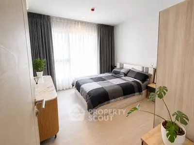 Modern bedroom with stylish decor and natural light, featuring a cozy bed and elegant furnishings.