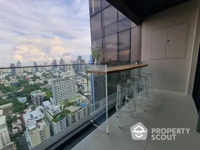 Stunning high-rise balcony with panoramic city views and modern seating area.