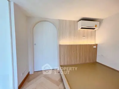 Modern minimalist bedroom with built-in air conditioning and stylish wood paneling.