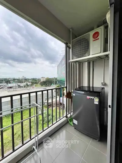 Spacious balcony with scenic view and modern appliances in urban apartment.