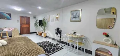 Cozy living room with modern decor, featuring a small dining area and stylish furnishings.