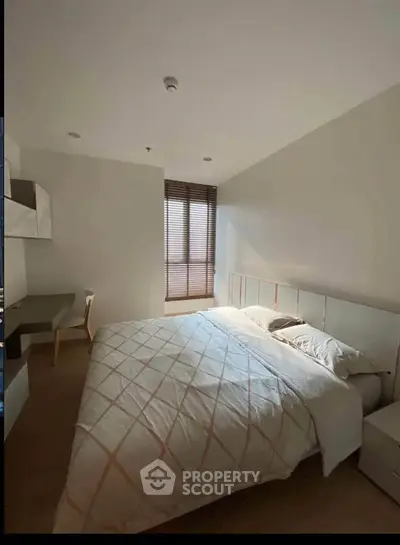 Spacious bedroom with modern decor and natural light, featuring a comfortable bed and stylish furnishings.