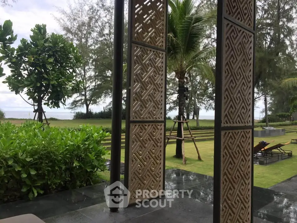 Luxurious beachfront property with lush garden and stylish outdoor decor, perfect for relaxation and leisure.