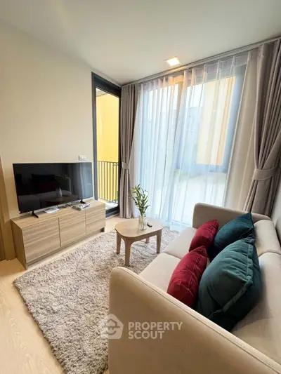 Modern living room with cozy sofa, TV, and balcony view in a stylish apartment.
