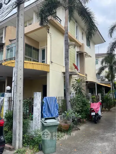 Charming three-story townhouse with lush greenery and modern design in a serene neighborhood.