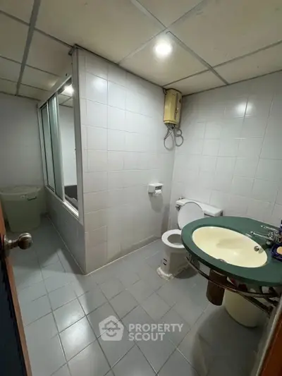 Spacious bathroom with modern fixtures and tiled walls in a contemporary home.