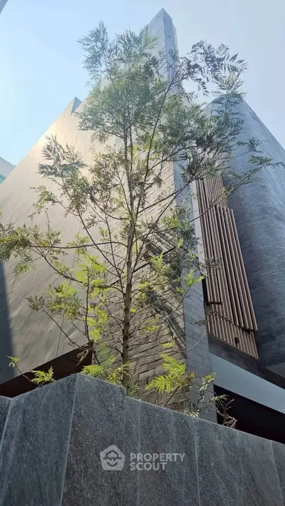 Modern architectural building facade with sleek design and lush greenery