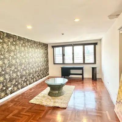 Spacious living room with stylish wallpaper and city view windows.