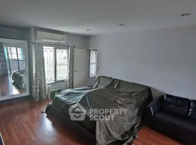 Spacious living room with hardwood floors and modern furnishings, perfect for relaxation and entertainment.