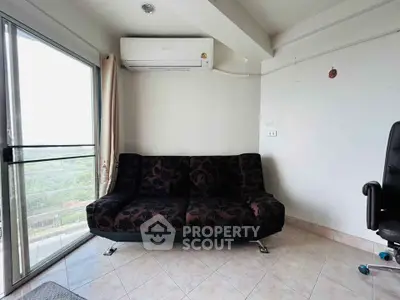 Modern living room with stylish sofa and air conditioning, featuring large windows for natural light.