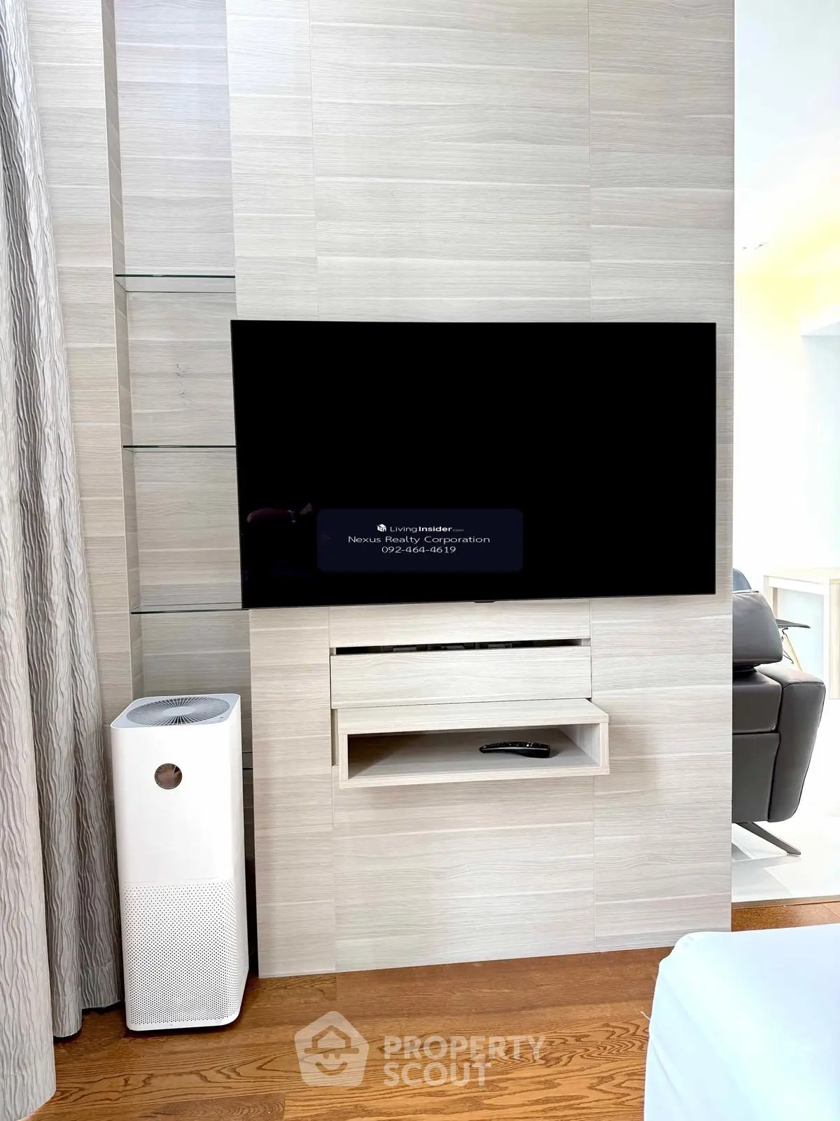 Modern living room with sleek TV setup and air purifier on wooden floor