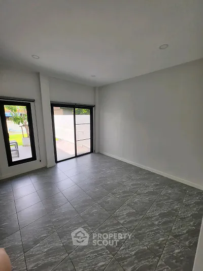 Spacious unfurnished room with large windows and tiled floor, perfect for customization.