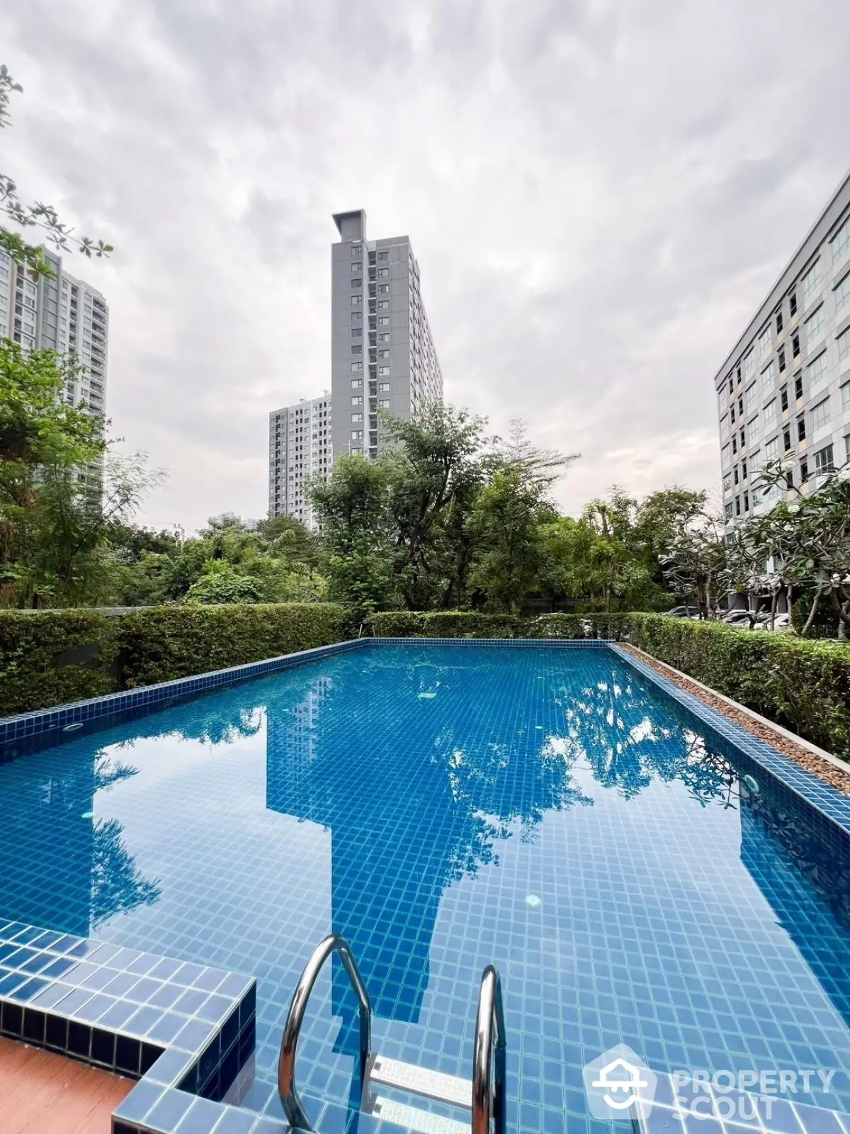 Luxurious residential pool with stunning cityscape view and lush greenery