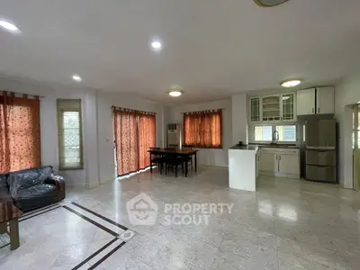Spacious open-plan living room with dining area and modern kitchen in a bright apartment.