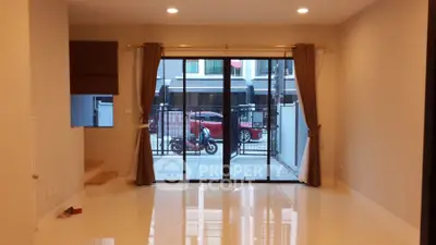 Spacious living room with large glass doors leading to a modern outdoor area.