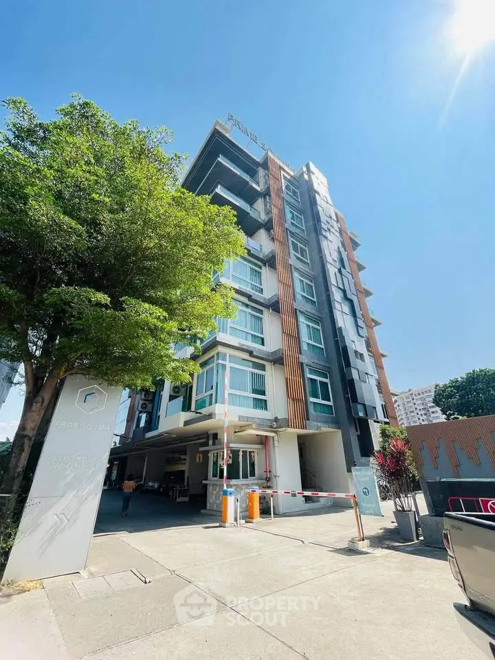 Modern apartment building exterior with sleek design and lush greenery, perfect for urban living.