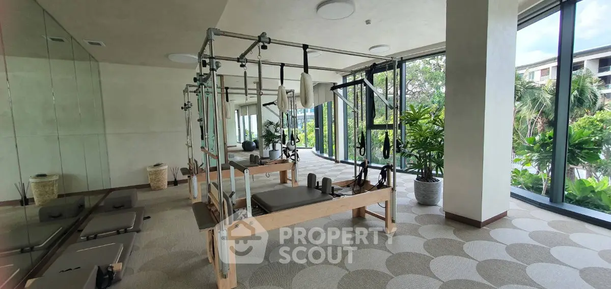 Spacious gym with modern equipment and lush garden view