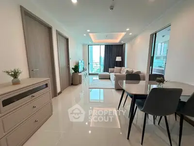 Modern living room with sleek furniture and large windows offering a stunning city view.