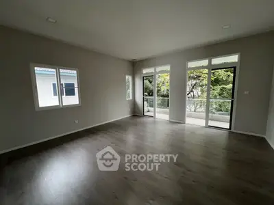 Spacious empty room with large windows and balcony access, perfect for customization.