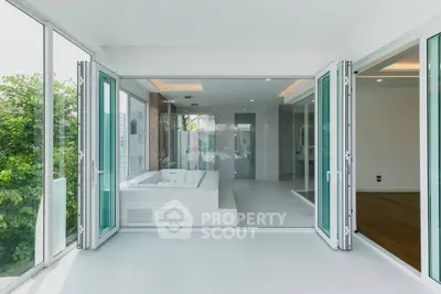 Luxurious modern bathroom with large glass doors and garden view