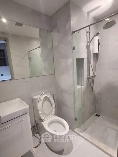 Modern bathroom with sleek design featuring glass shower and contemporary fixtures.