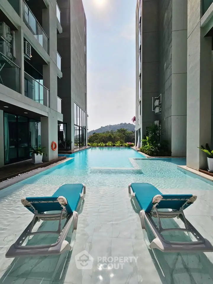 Luxurious poolside view with modern lounge chairs and scenic backdrop.