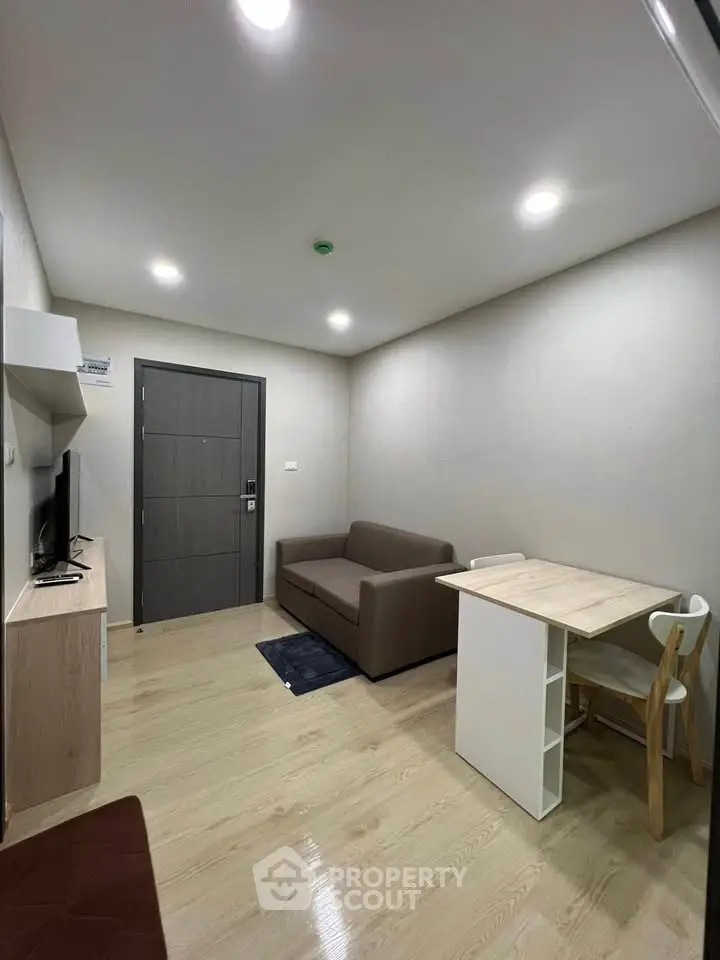 Modern living room with sleek furniture and wooden flooring in a cozy apartment.