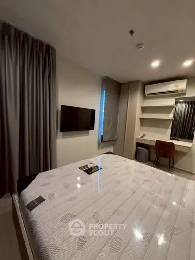 Modern bedroom with sleek design, featuring a wall-mounted TV and stylish furniture.