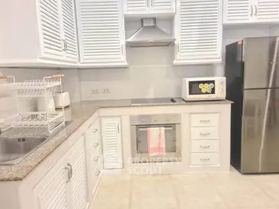 Modern kitchen with stainless steel appliances and sleek white cabinetry