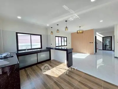 Spacious modern kitchen with open layout and stylish lighting fixtures