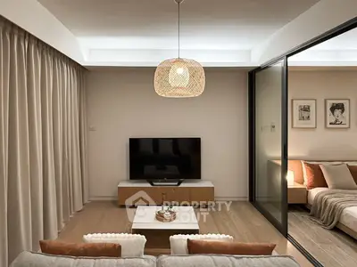 Modern living room with cozy decor and sliding glass doors to bedroom