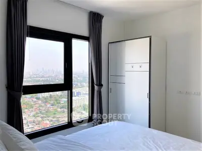 Modern bedroom with stunning city view and sleek wardrobe design.
