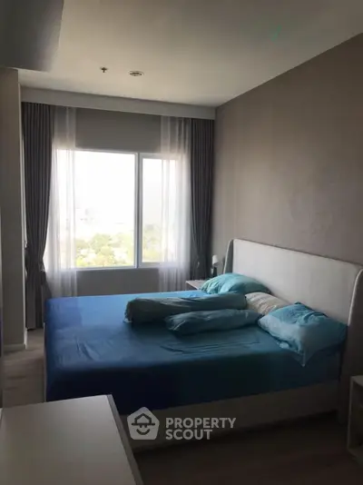 Spacious bedroom with large window offering natural light and serene views, perfect for relaxation.
