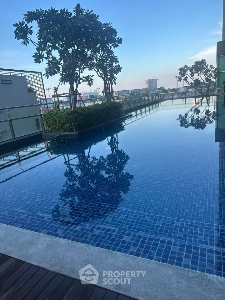 Luxurious rooftop pool with stunning city views and lush greenery, perfect for relaxation and leisure.