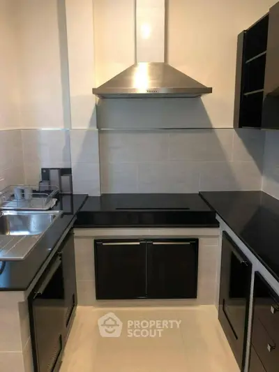 Modern kitchen with sleek black countertops and stainless steel appliances