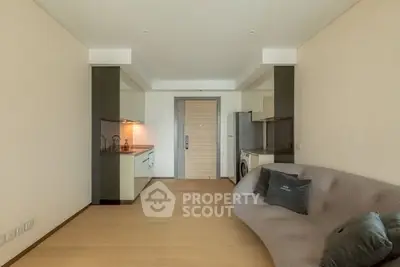 Modern living room with sleek kitchen and stylish sofa in open layout apartment.
