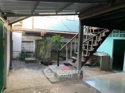 Charming rustic outdoor area with staircase and garden space, perfect for creative renovations.
