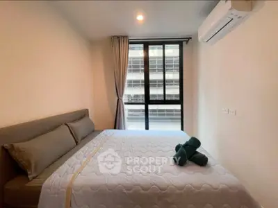 Modern bedroom with large window and air conditioning in urban apartment