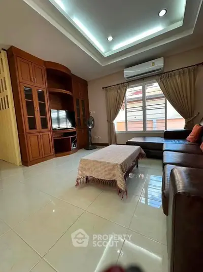 Spacious living room with elegant wooden cabinetry and cozy seating area.