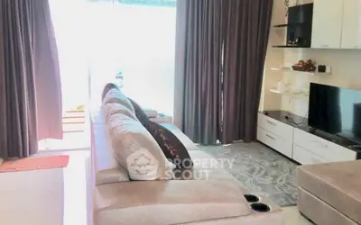 Spacious living room with modern sofa and entertainment center, perfect for relaxation.
