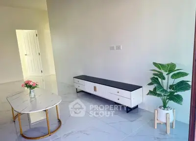Modern living room with sleek furniture and elegant decor, featuring a stylish coffee table and indoor plant.
