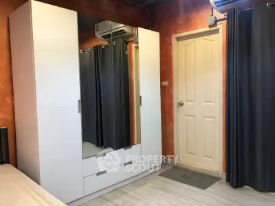 Cozy bedroom with modern wardrobe and air conditioning, perfect for comfortable living.