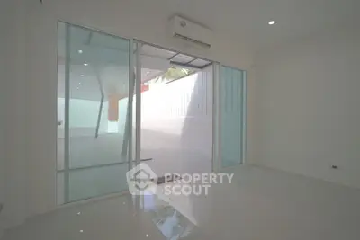 Spacious modern room with sliding glass doors leading to a private patio.