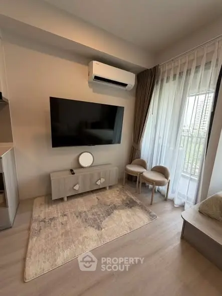 Modern living room with large TV, air conditioning, and balcony view in stylish apartment.