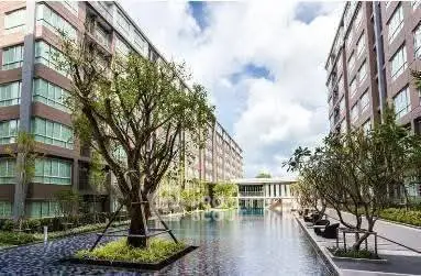 Luxurious apartment complex with serene pool and lush greenery, perfect for modern living.