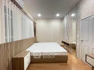 Spacious modern bedroom with elegant wooden furniture and large windows