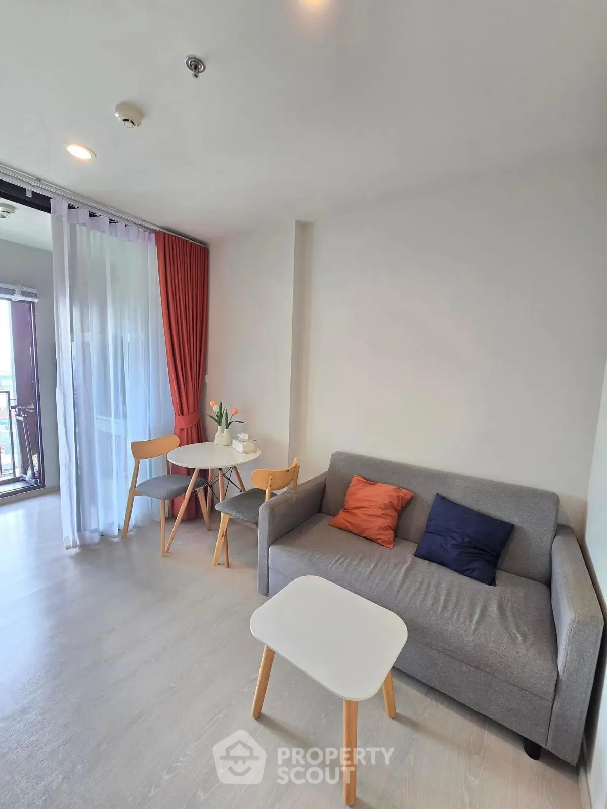 Cozy living room with modern furniture and balcony access in a stylish apartment.